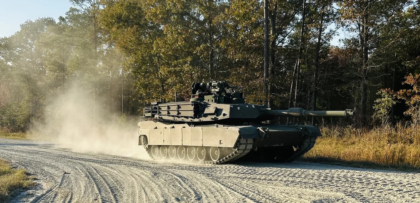 M1 Abrams main battle tank rolling through a training area — the kind of unit history Roll Call preserves
