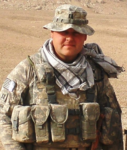 Matt Simon — Founder & CEO, Service Alliance. Pictured in combat gear in Afghanistan.